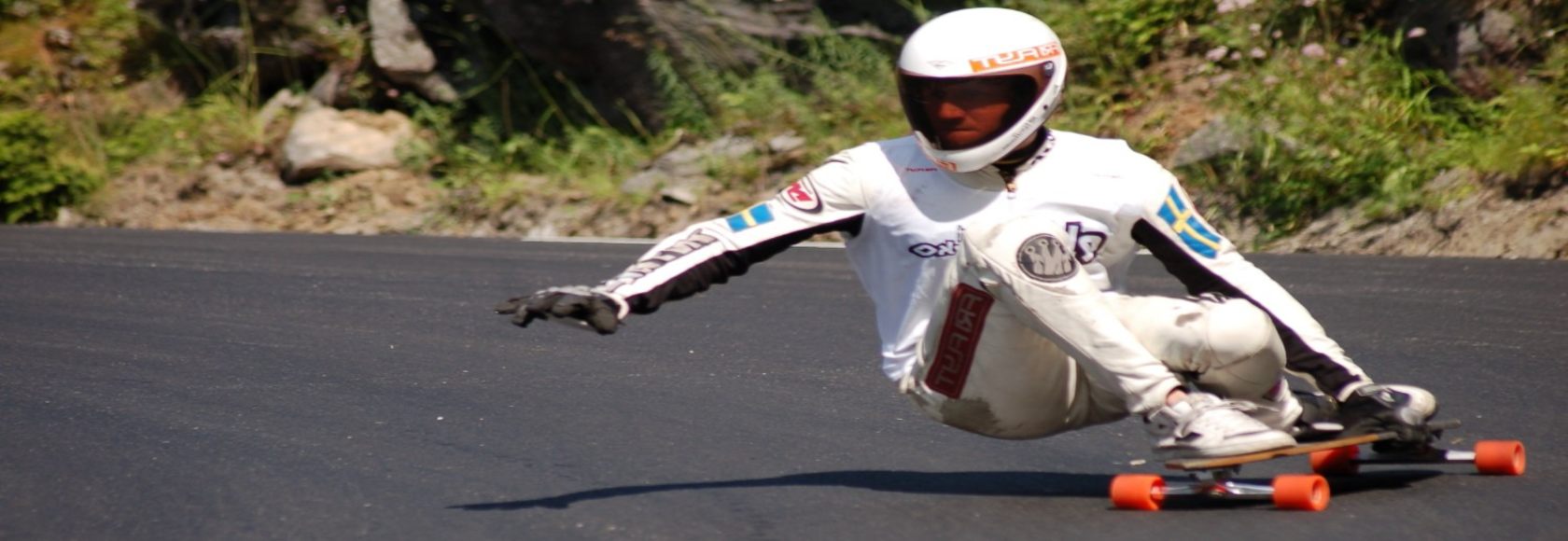 Man in a white suit going down a hill