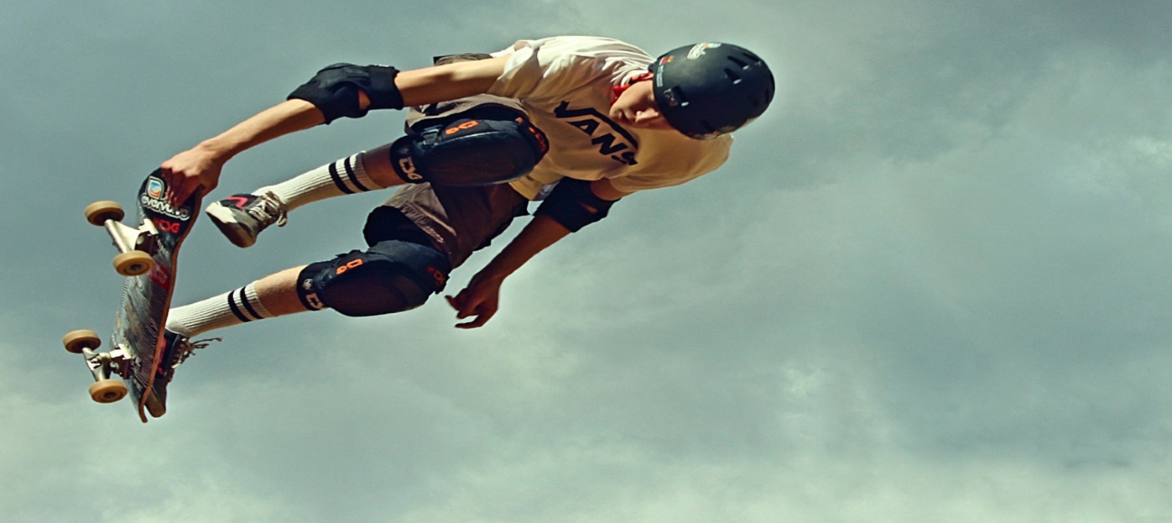 Guy does trick in mid-air with saftey gear on