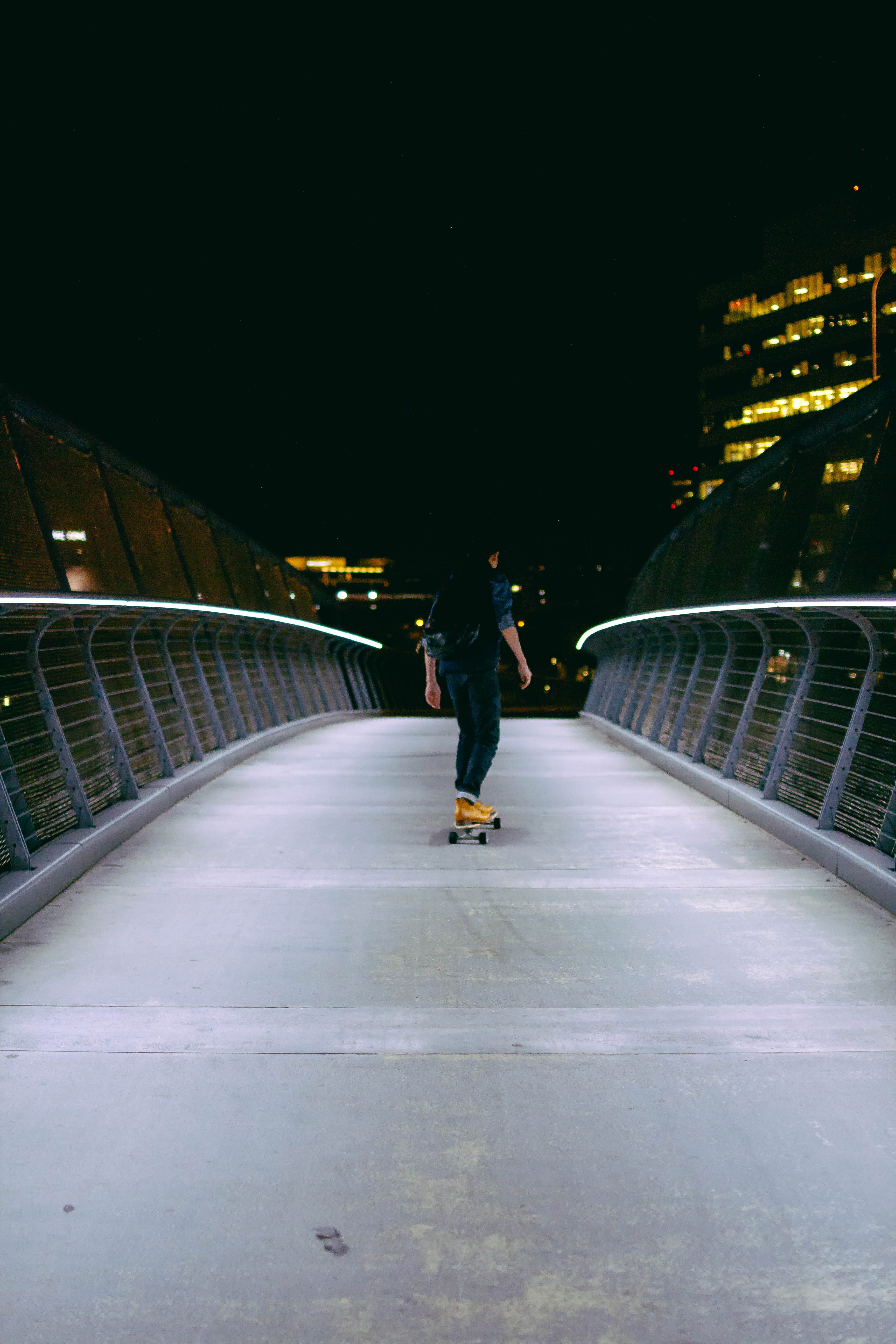 a guy riding his longboard at night